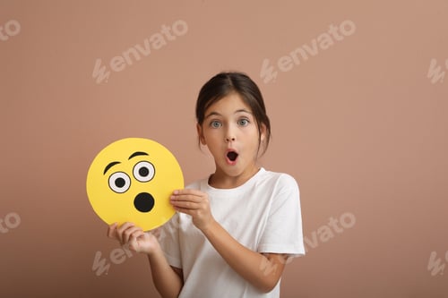 Preview: Emotional little girl holding face with shocked emoji on pale pink background