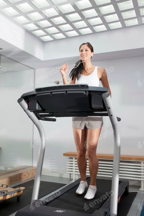 Preview: Smiling woman exercising on treadmill
