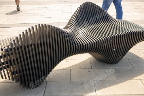 Preview: Close-up of a wooden curved art bench in a city park