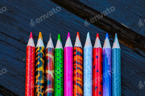 Preview: Colored pencils on an open texture table. Set of colored pencils on the background of the table