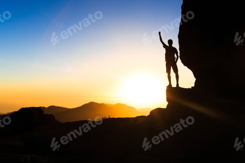 Preview: Man hiking climbing silhouette success in mountains sunset