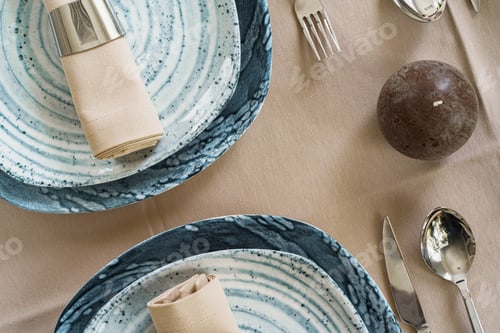 Preview: Details of a stylish table setting with textured ceramic dishes