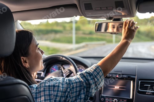 Preview: Attractive young woman driving a car, view from inside.