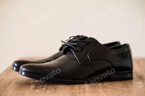 Preview: Closeup shot of classic black leather male shoes on a brown surface