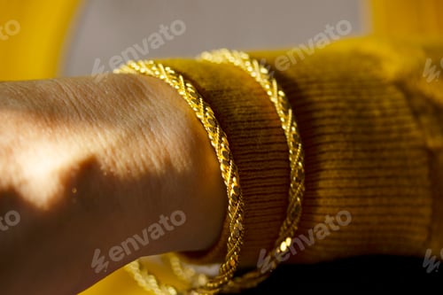 Preview: young woman wearing gold bracelet