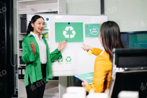 Preview: Businesswomen discussing net zero sustainability strategy with renewable energy models, solar panels
