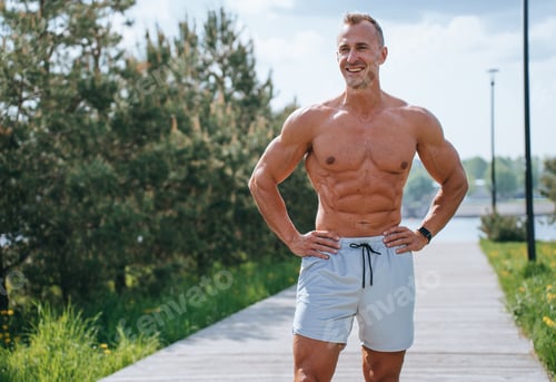 Preview: Strong young adult caucasian man in sportswear shorts stands against transparent background.