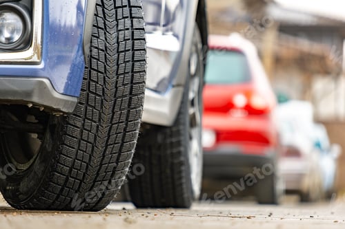 Preview: Closeup of parked car on a city street side with new winter rubber tires