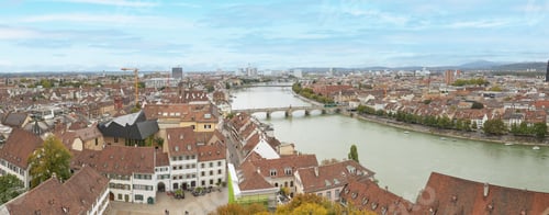 Preview: Aerial view of a picturesque small town situated along a river, with a variety of urban buildings