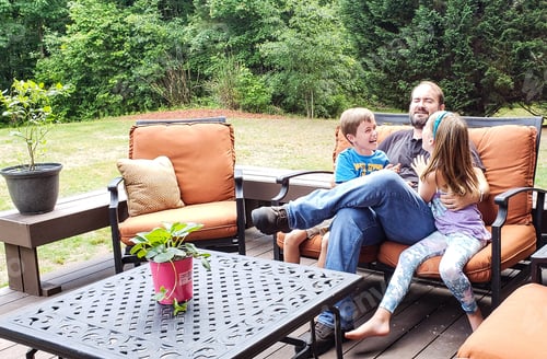 Preview: Gen z kids teasing dad on backyard deck on fathers day in family fun and candid moments.