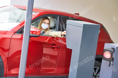 Preview: Woman getting ticket from parking meter in underground parking