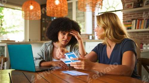 Preview: Two Friends or Couple Discussing Financial Documents While Working at Home in Cozy Living Room