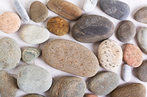 Preview: Flat lay background of smooth sea stones on a light background top view