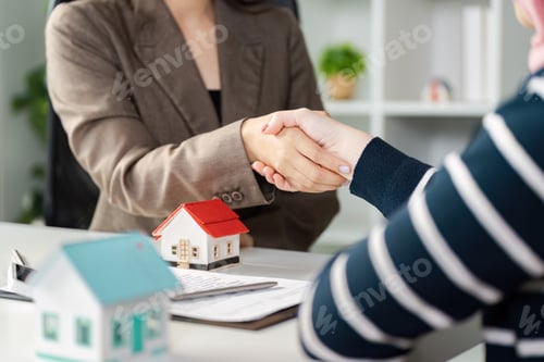 Preview: Real estate agent shaking hands with a client, finalizing a property