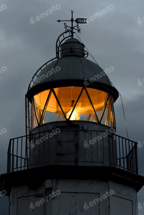 Preview: Shining lighthouse against cloudy sky