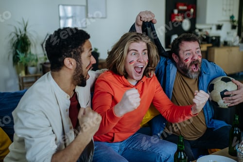 Preview: Happy German football fans friends watching football at home and celebrating