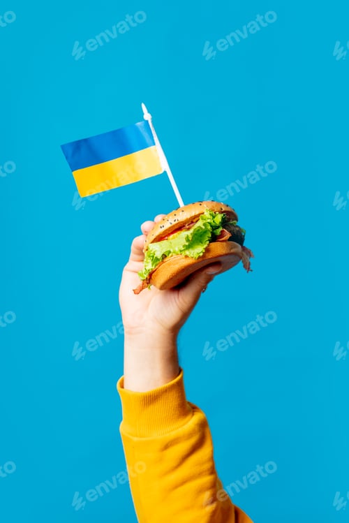 Preview: Male hold burger with ukrainian flag