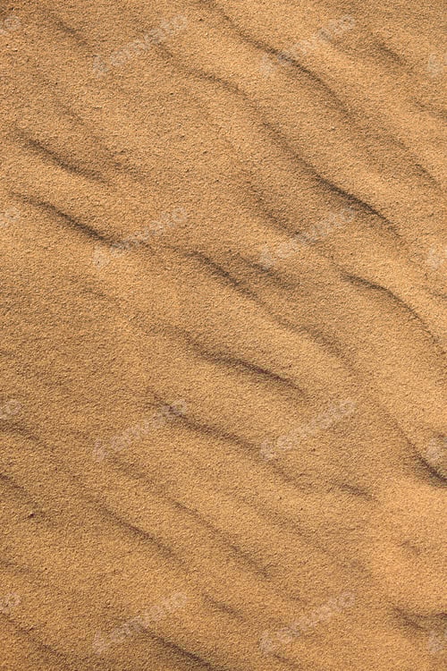 Preview: Texture of sand in the desert close-up background. A dune with a pattern of sand waves