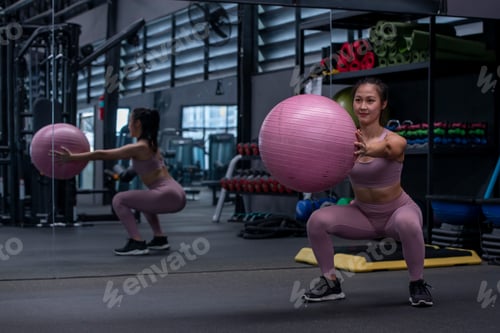 Visualização: mulher esportiva vestindo roupas esportivas e uma bandana está realizando um exercício de Pilates envolvendo uma bola de fitness