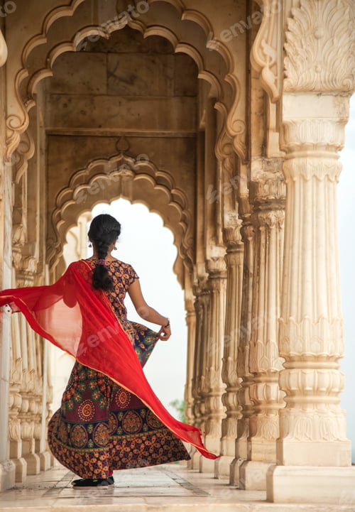 Preview: Young female tourist dancing between arches and Pillars.