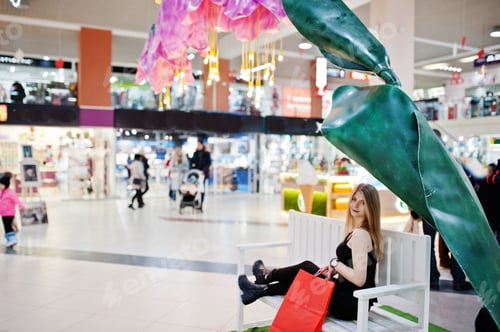 Preview: Girl with shopping bags in the mall sitting on bench.