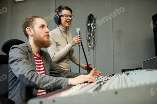 Preview: Sound designer and singer recording song in production studio