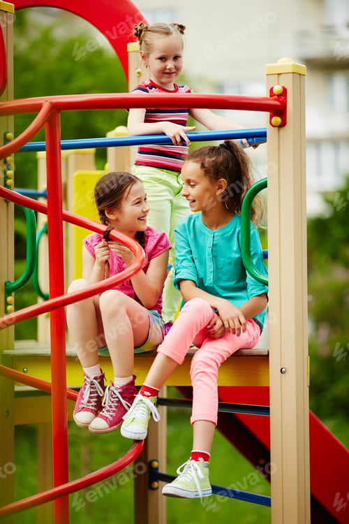 Children Laughing on Playground Equipment on a Sunny Day