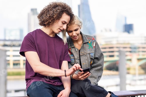 Preview: Happy couple talking sitting near River Thames