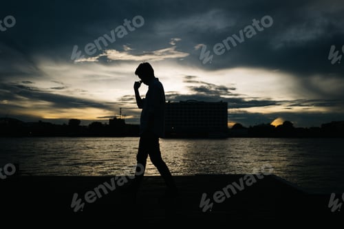 Preview: Man thoughtfully walking by the river