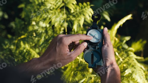 Preview: Hands of a boy opens the compass in the mountains to orient himself in the hike. Handheld shoot