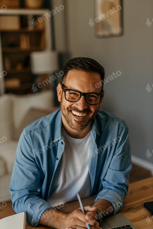 Preview: Man wearing eyeglasses smiling while working from home
