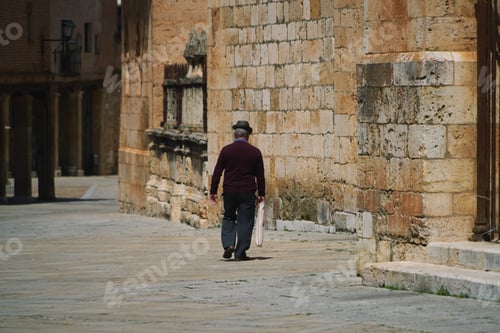 Preview: Male walking on the pavement among the old and stone buildings