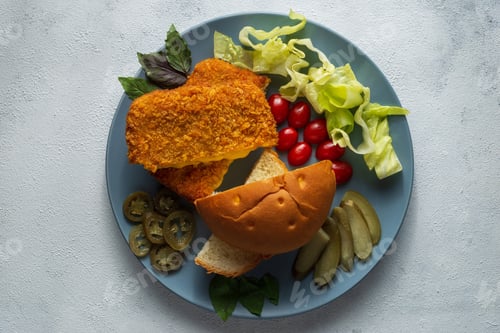 Preview: Top view of sliced bread with meat cutlets, pickles, jalapeno pepper, tomatoes and cabbage