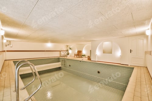 Preview: a swimming pool with green tiles and a silver rail