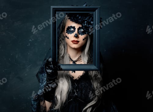 Preview: portrait of a girl in a witch costume with photo frame on a dark background
