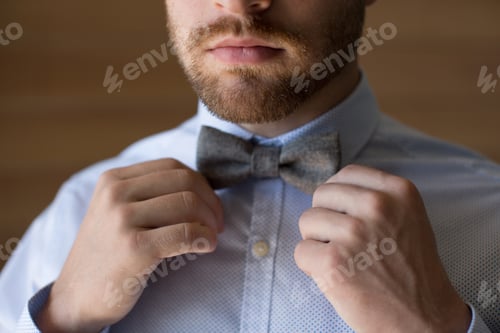 Preview: Man Adjusting Bowtie Before an Event