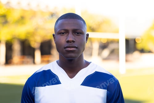 Preview: African American young male athlete standing on field outdoors, looking serious, copy space