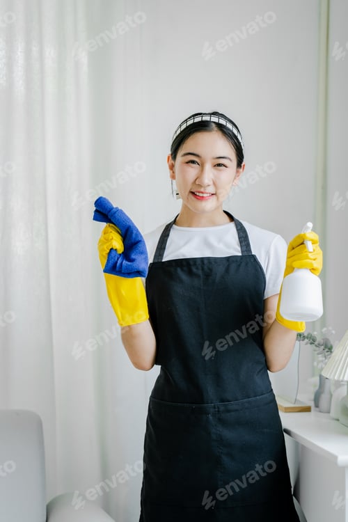 Preview: Young women use cleaning cloths and disinfectant sprays to wipe tables and mop floors in the house.