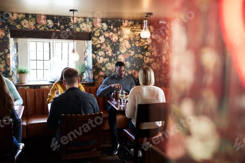 Preview: Group Of People Eating In Restaurant Of Busy Traditional English Pub