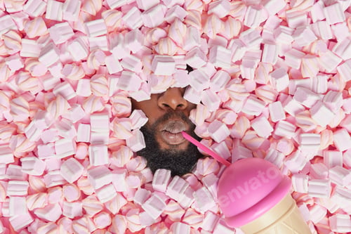 Preview: Faceless black bearded man covered with tasty appetizing marshmallow drinks cocoktail has cheat day