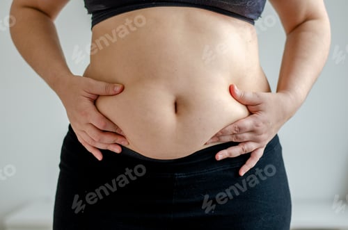 Preview: Overweighted woman squeezing belly seen from front