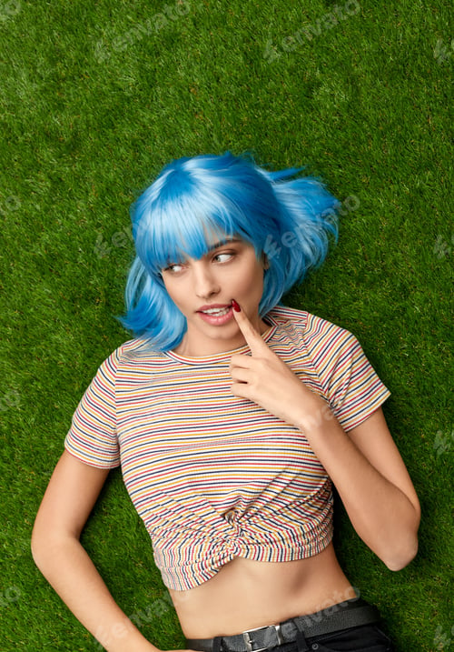 Preview: Woman lying on grass and touching corner of mouth