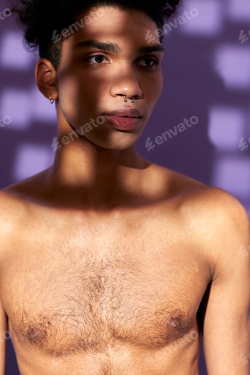 Preview: Close-up verticale portrait of young man posing with shadow on face. Model transgender. Naked