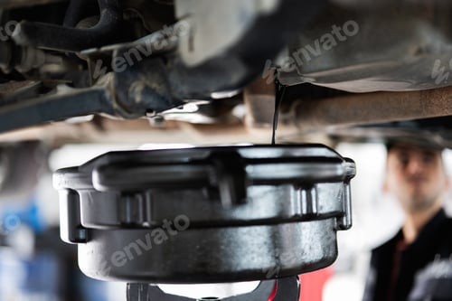 Preview: Mechanic performing an oil change in an auto repair shop