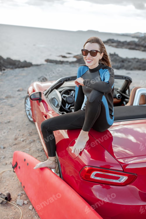 Preview: Young surfer with surfboard on the sports car on the beach