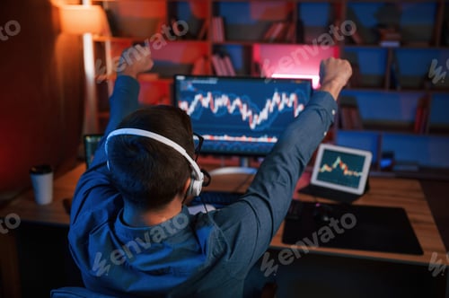 Preview: View from behind. Stock trader is working by pc indoors. Conception of exchange and money