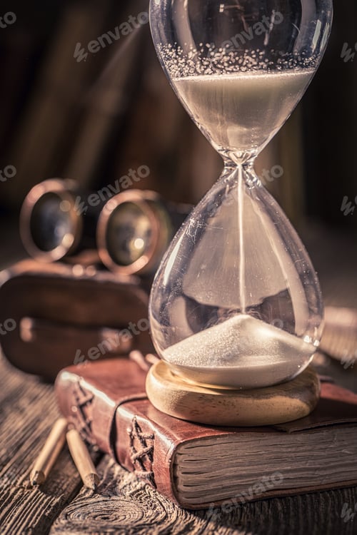 Preview: Vintage hourglass and journal with binocular, books and compass.