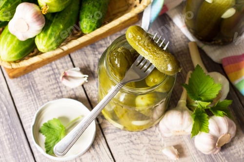 Preview: Marinated cucumbers gherkins. Pickles gherkins with garlic wooden table.