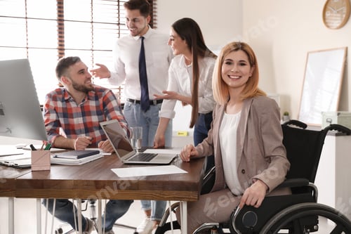 Preview: Woman in wheelchair with her colleagues at workplace