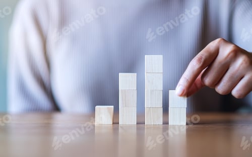 Preview: Closeup image of a hand stacking and picking blank wooden cube block